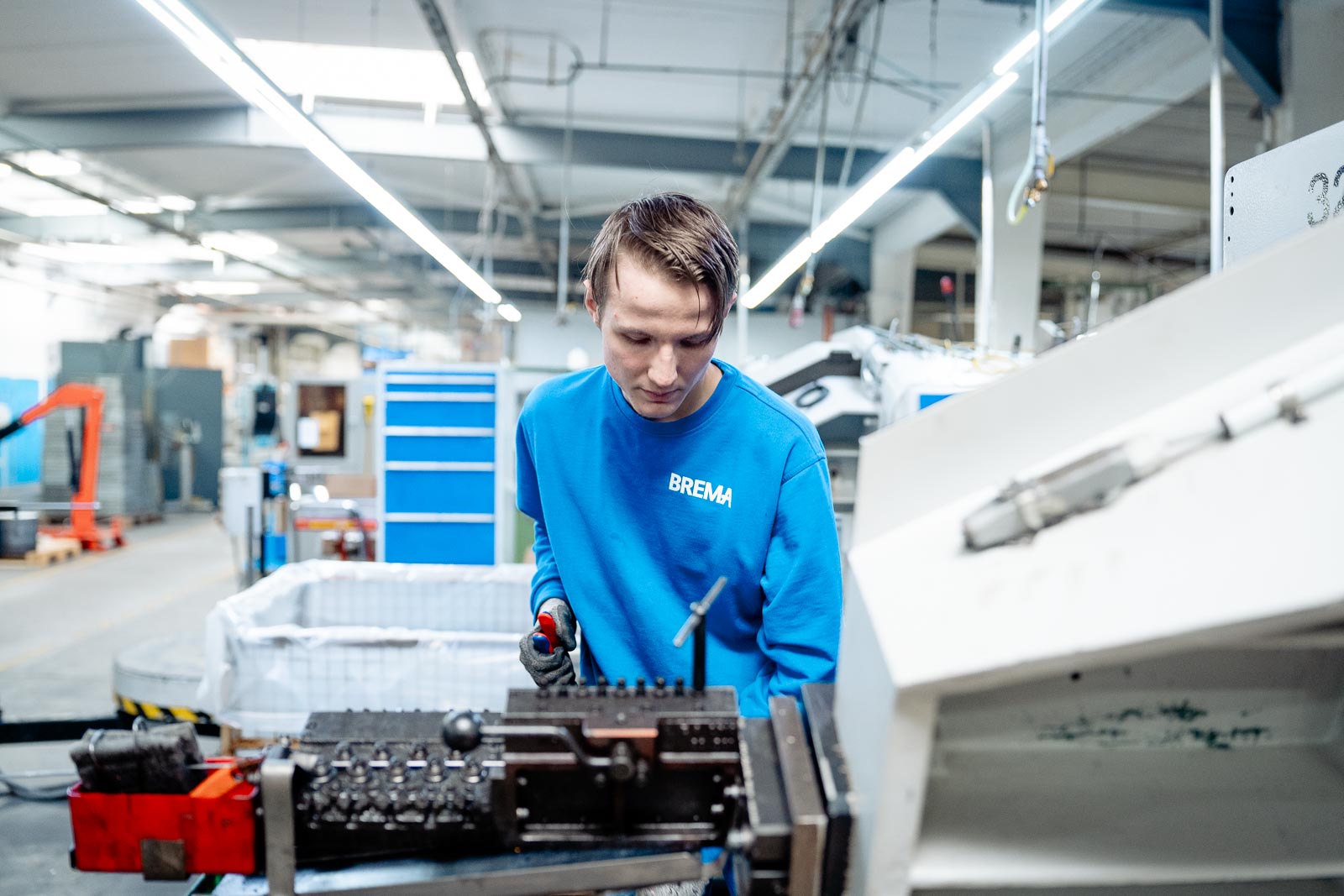 a man in a blue shirt working on a machine